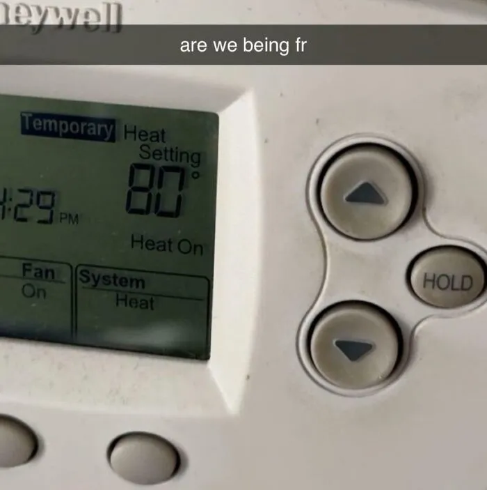 A household thermostat set to a high temperature of 80 degrees, highlighting roommate stories about energy bills.