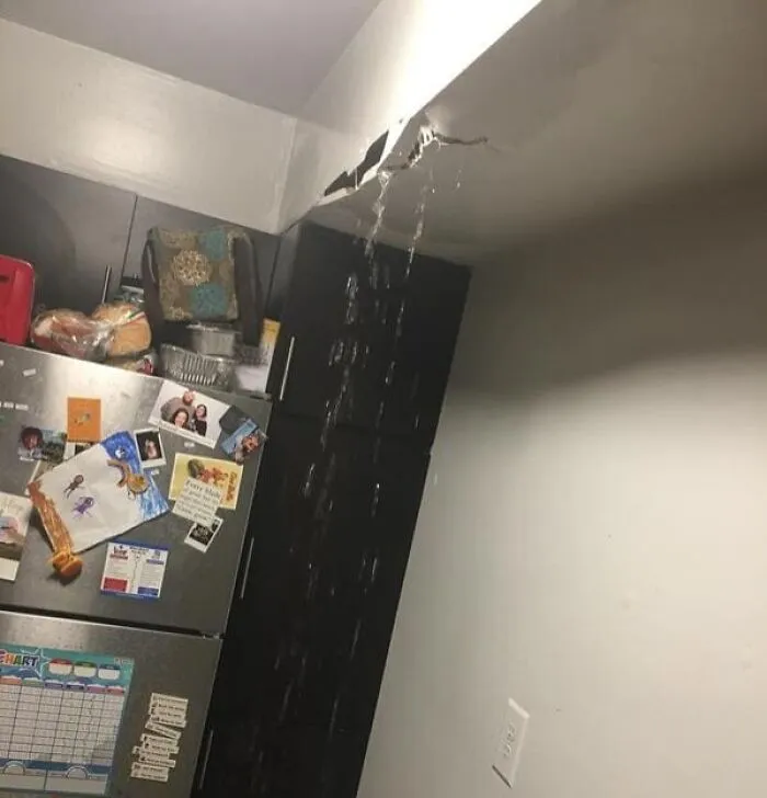 Water leaking from a cracked kitchen ceiling, illustrating terrible roommate stories.