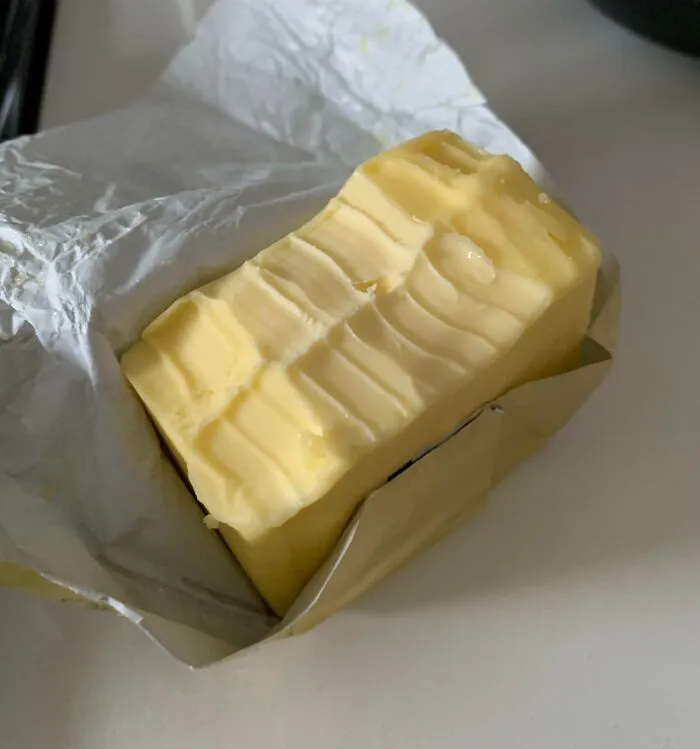 A block of butter with knife scrapes showcasing roommate stories about poor kitchen sharing