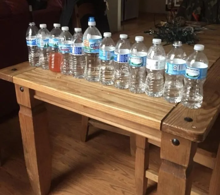 Roommate stories showing a wooden table crowded with half-empty plastic water bottles.
