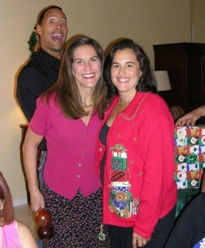 Dwayne The Rock Johnson hilariously photobombs two women in this background moment.