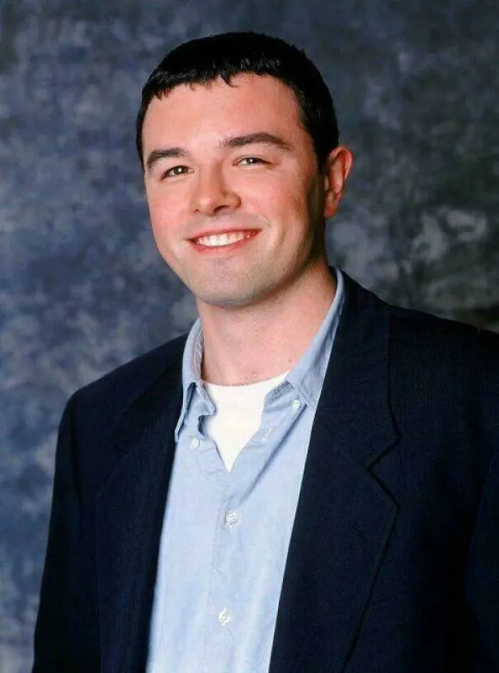 A young Seth MacFarlane smiling in a dark blazer, reminiscent of events that happened in 2001.