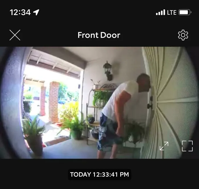 Doorbell camera footage of one of the infuriating neighbors looking closely into a front door.