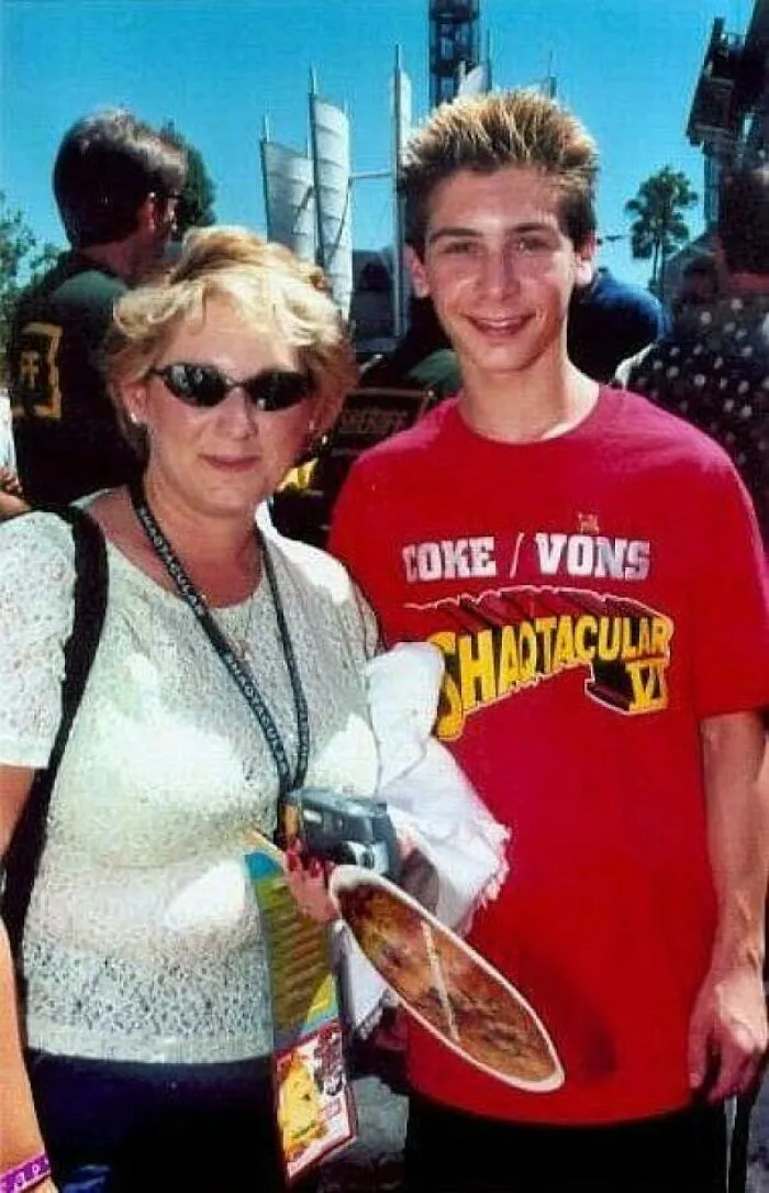 A mother and son posing together in early 2000s fashion.