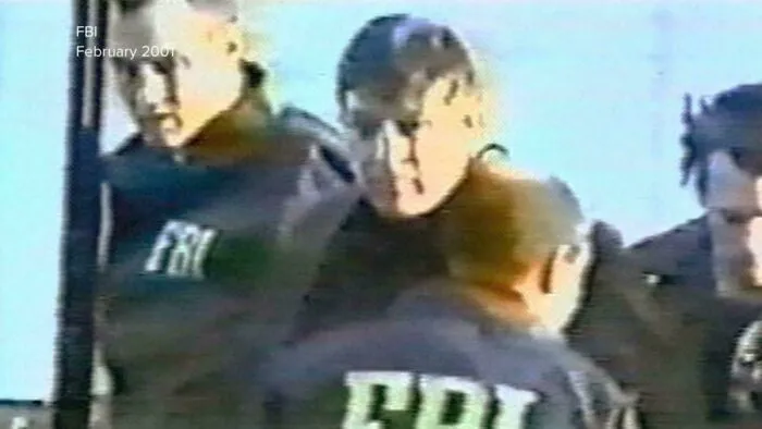 Grainy surveillance image of FBI agents escorting a man, a memorable event that happened in 2001.