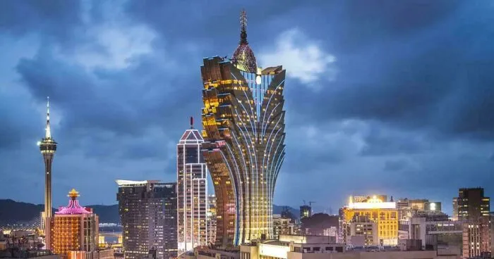Modern illuminated Macau skyline at night featuring Grand Lisboa building.