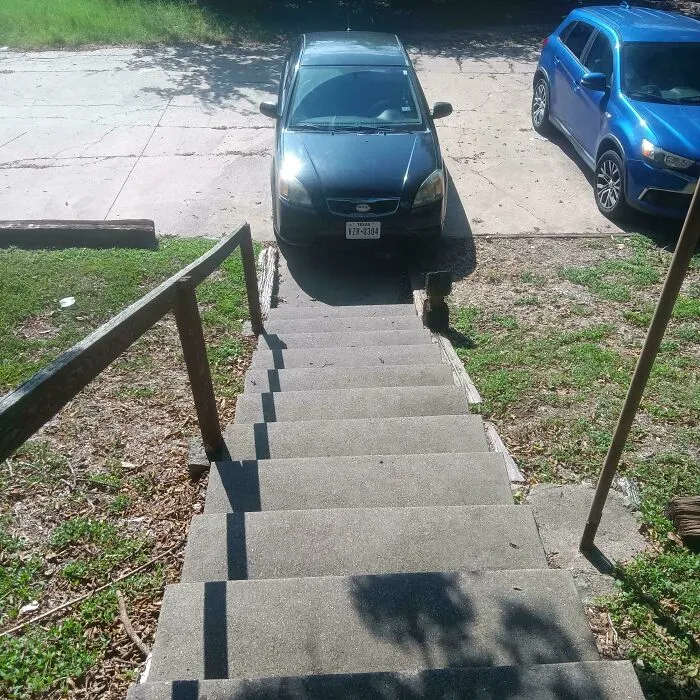 Car parked directly at the bottom of outdoor stairs, blocked by infuriating neighbors.