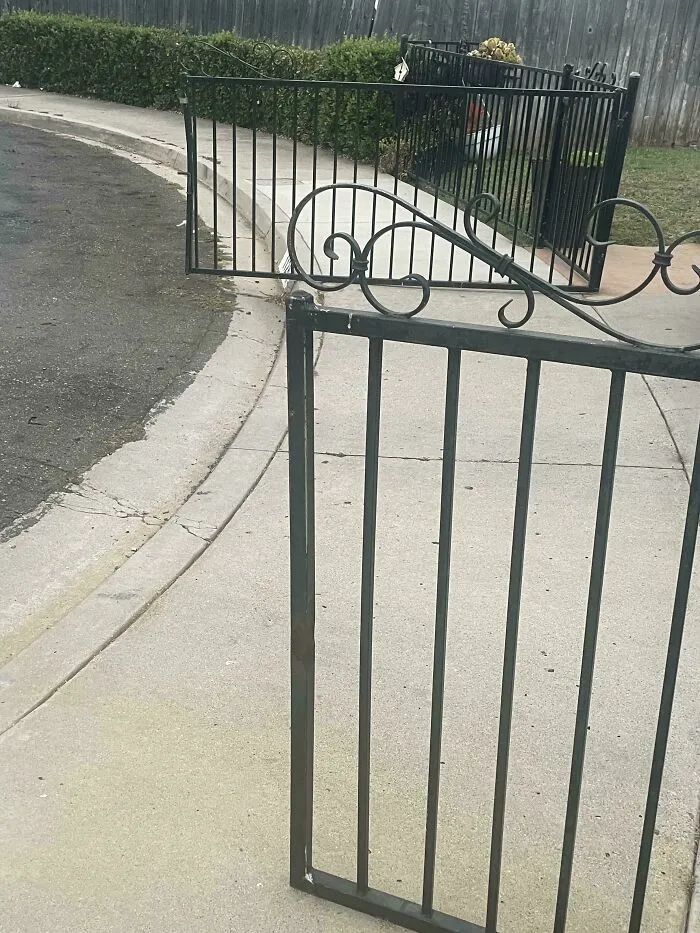 Open black wrought iron gate blocking a public sidewalk by infuriating neighbors.