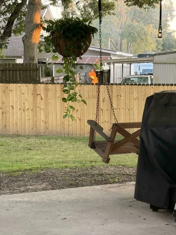 Flames rising behind a wooden fence, illustrating actions of infuriating neighbors.