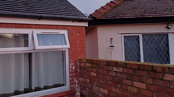 Infuriating neighbors close exterior house walls and brick boundary wall.