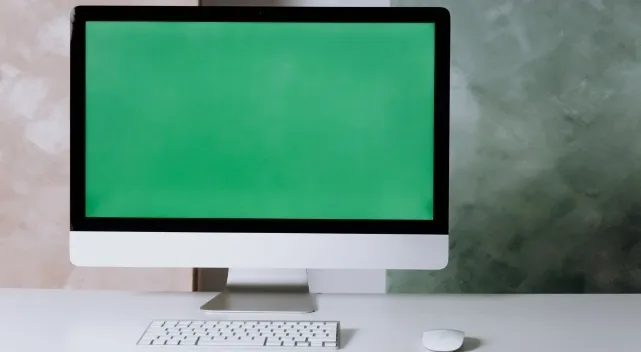 Desktop computer setup with a green screen illustrating a CPU tech question.