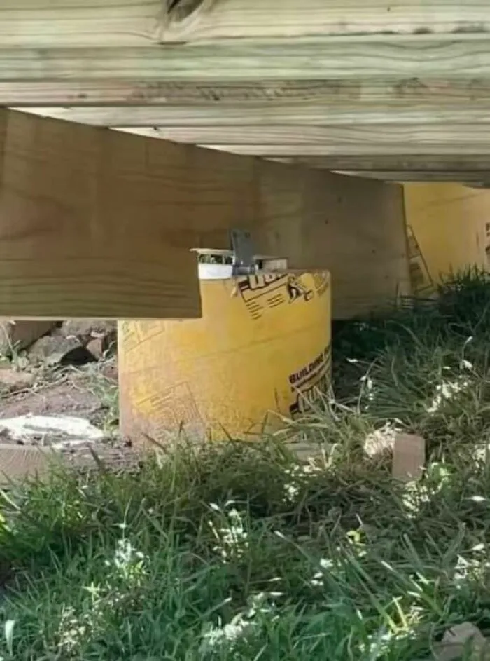 Construction fail using a plastic bucket as a support pillar under a wooden structure