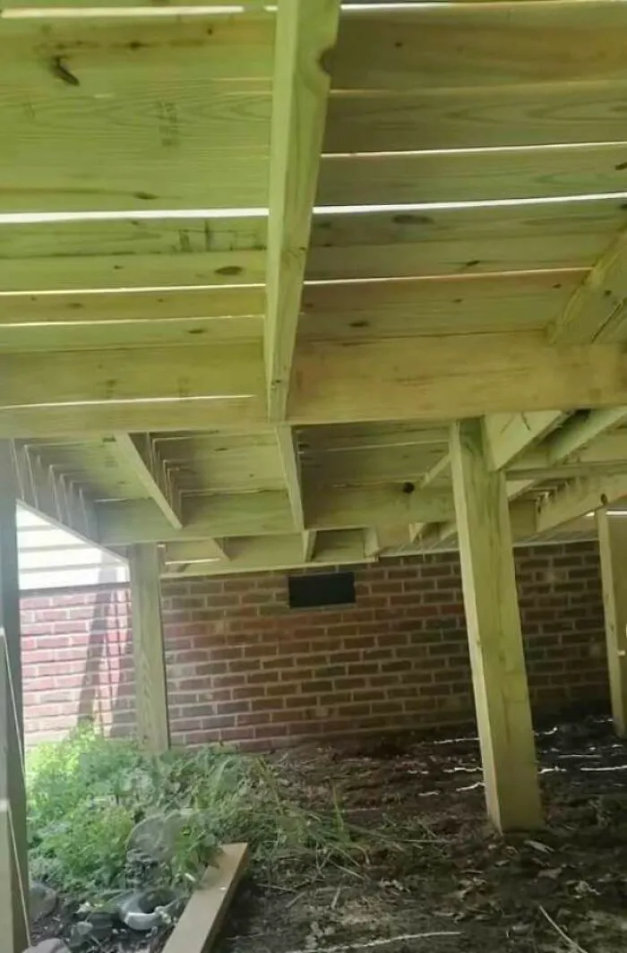 Poorly built wooden deck structure with uneven and unstable supports