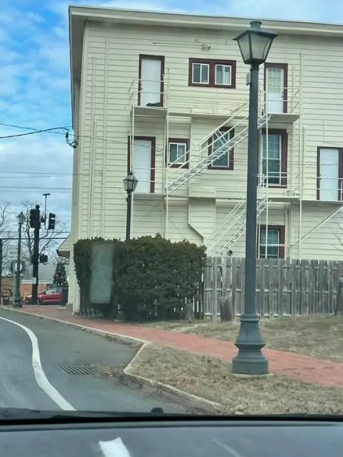 Building fire escape with doors opening to a fence and no safe exit on ground