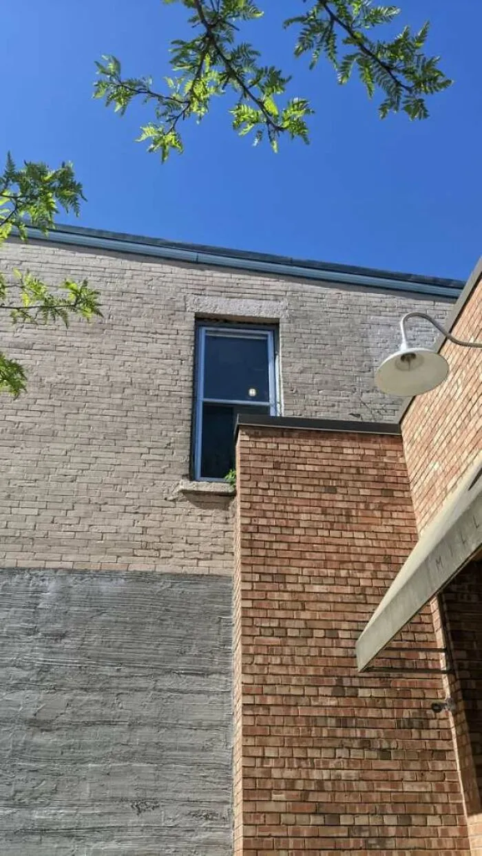A window installed directly behind an exterior brick wall, showing hilarious construction fails.