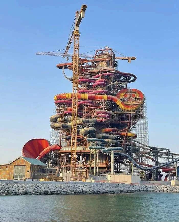 Complex waterpark construction with tangled slide tubes and crane