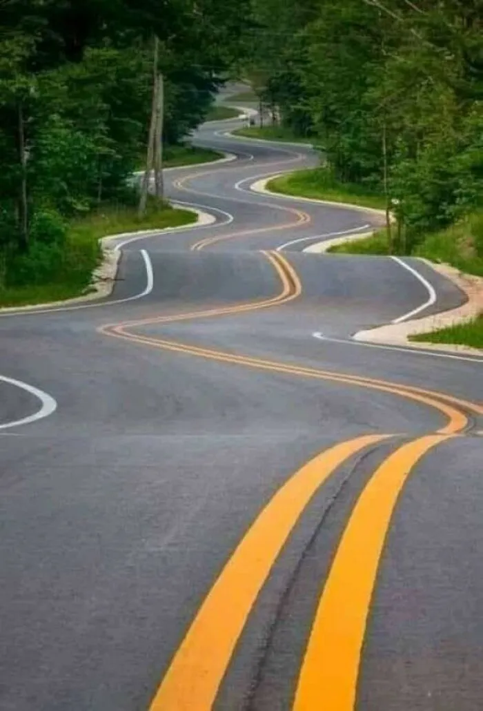 Road with poorly painted winding double yellow lines in construction fail