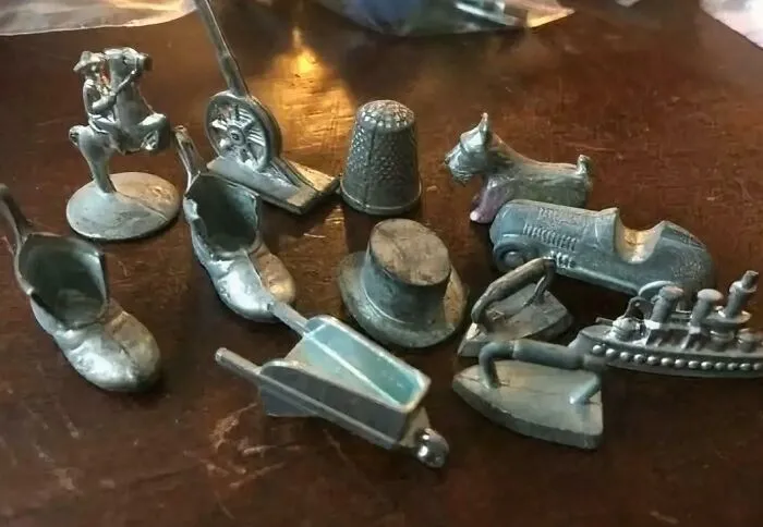 Collection of old-fashioned miniature metal toys on dark wooden table