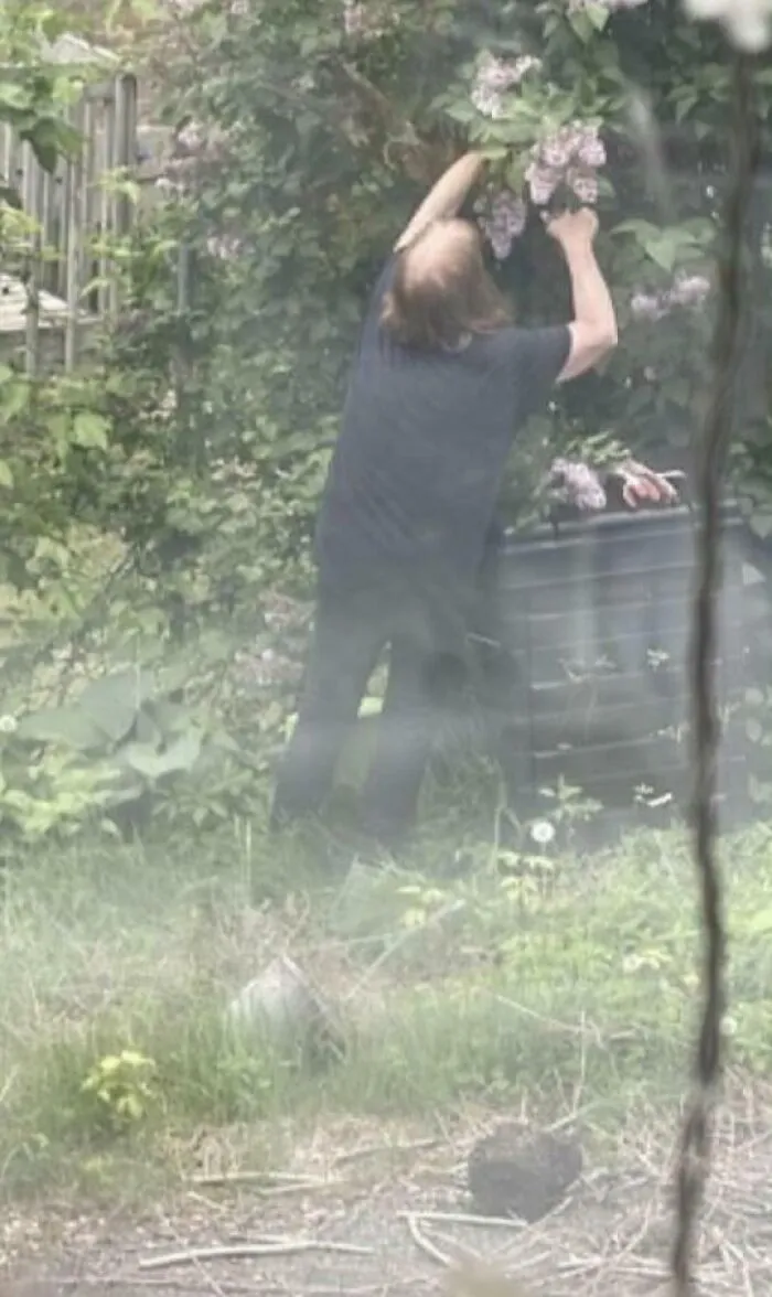 Person cutting bushes over property line showcasing bad infuriating neighbors.