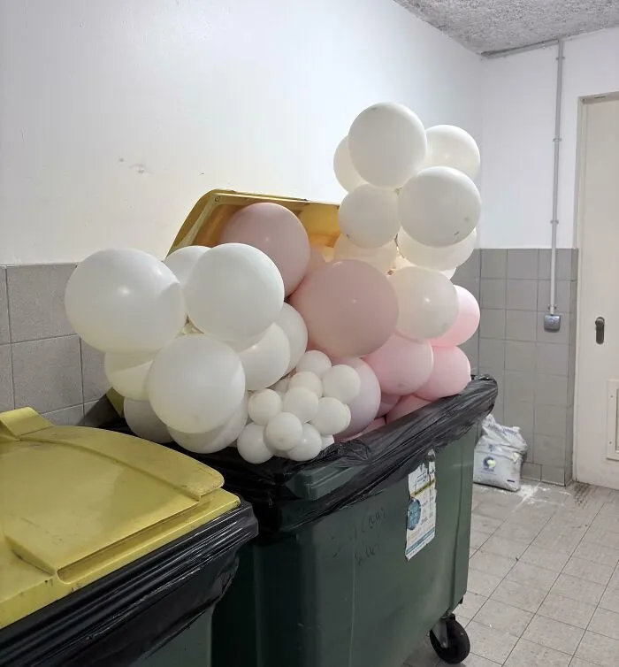 Overfilled trash bins stuffed with party balloons, showing inconsiderate neighbors.