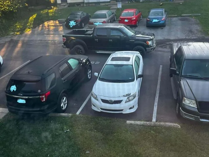 Aerial view of cars parked improperly in a lot showing bad infuriating neighbors habits.