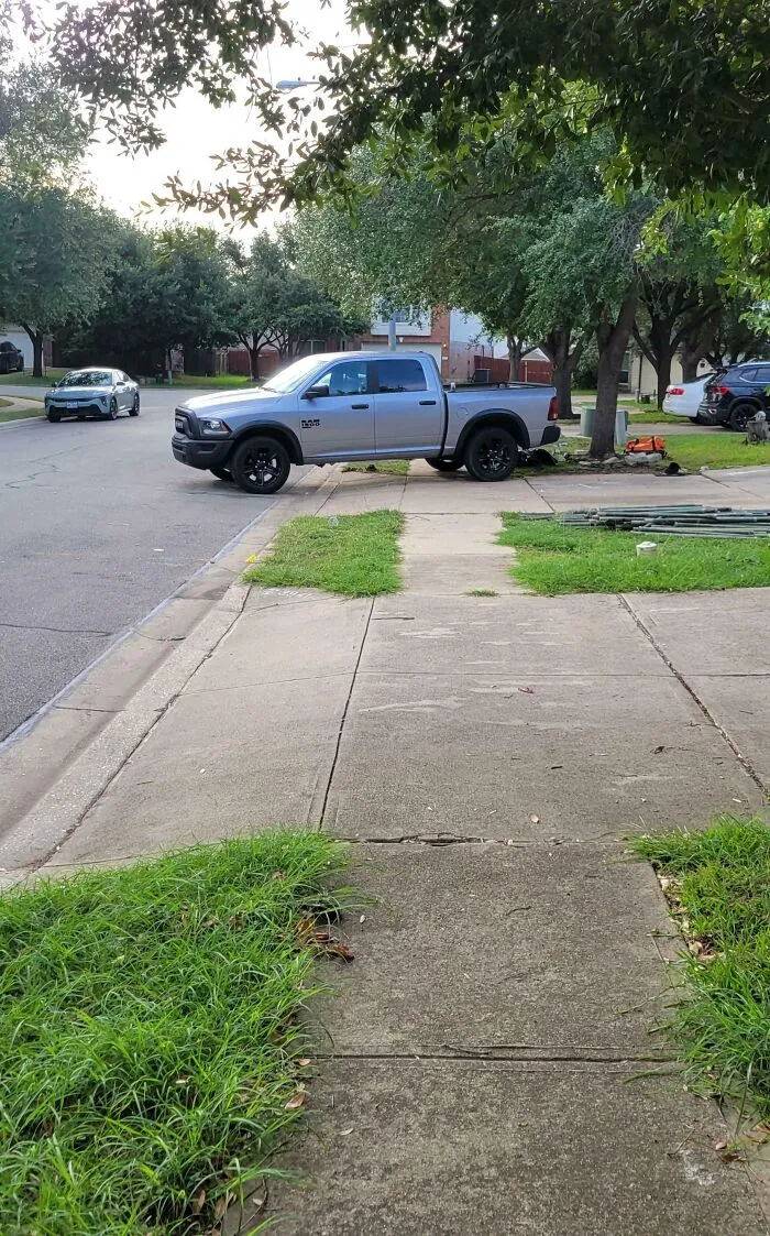 A pickup truck parked completely across a public sidewalk, a classic move by infuriating neighbors.