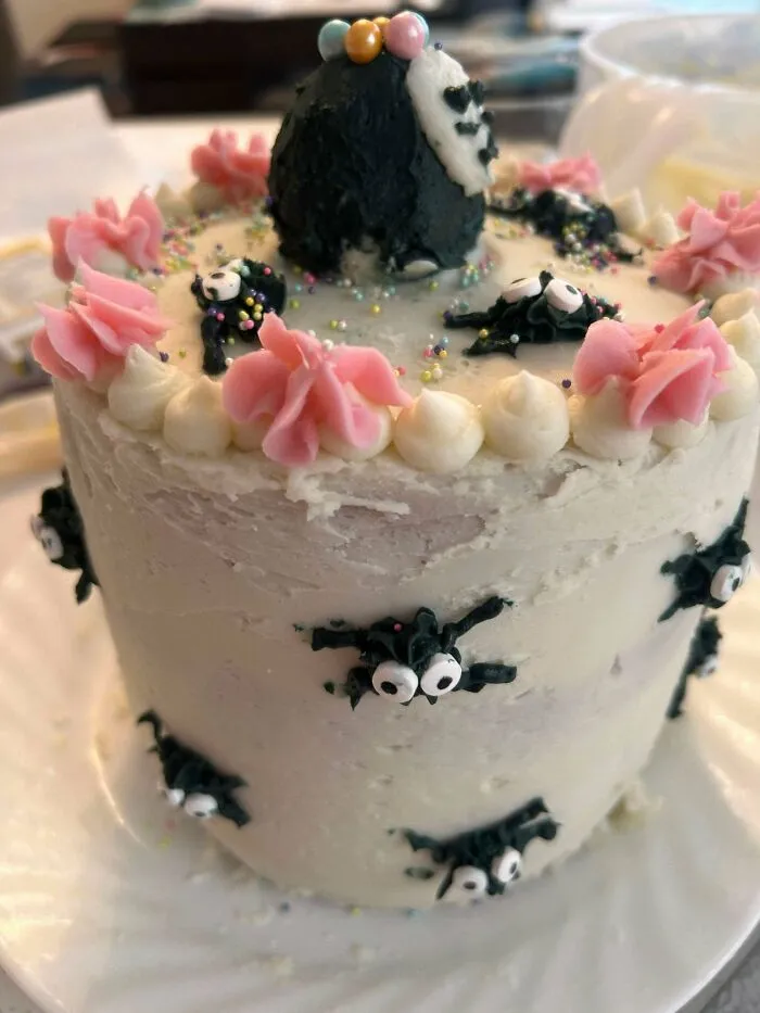 Small white cake with black soot sprite decorations as a cute baking fail