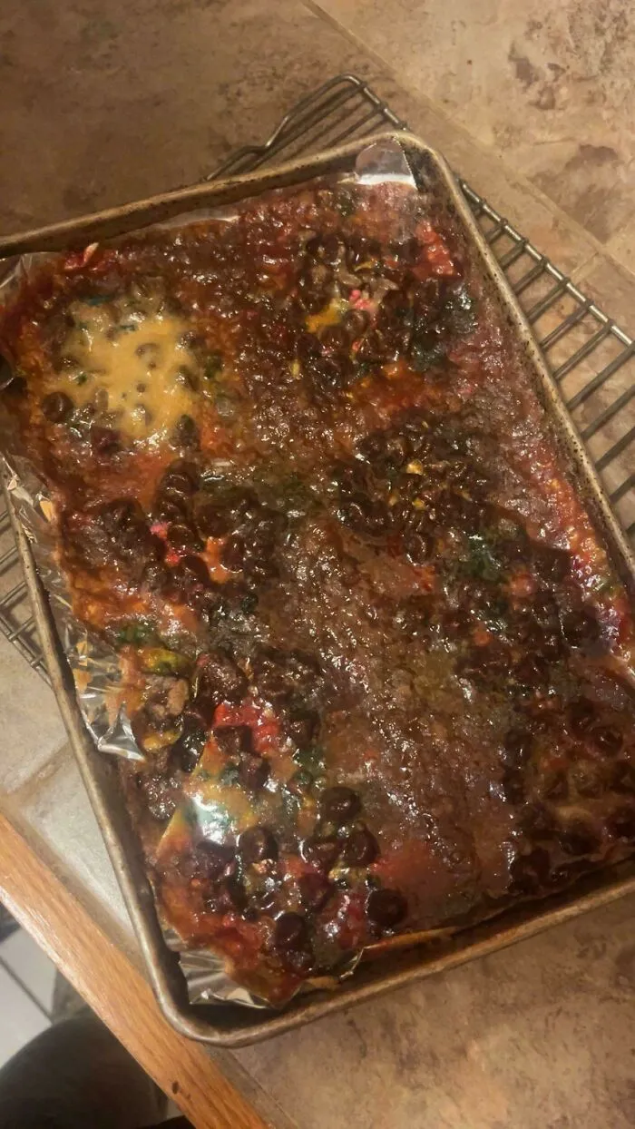 Messy tray of burnt baked goods with melted chocolate chips showing a baking fail.