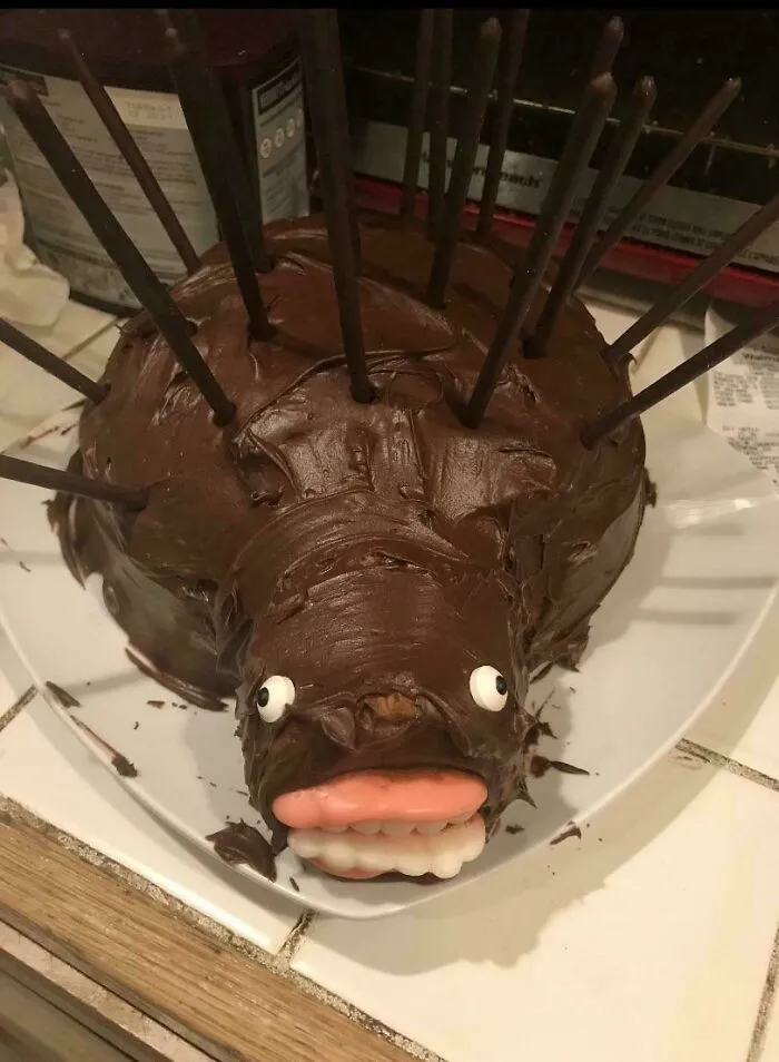 Funny chocolate cake shaped like an animal with stick spikes illustrating a baking fail