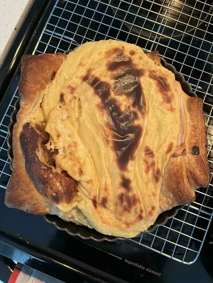 Overcooked unevenly browned pie crust on a rack showing a baking fail.