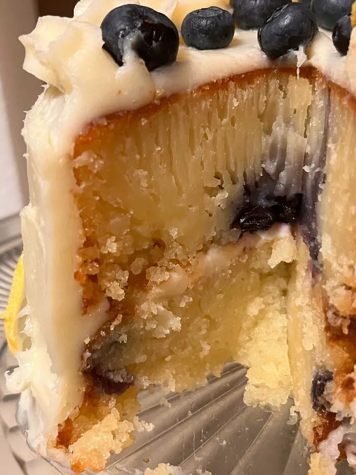 A close-up of a dense, unbaked-looking blueberry cake interior showing a baking fail.