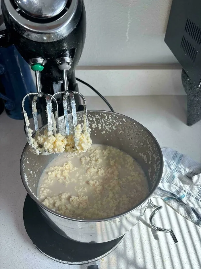 Curdled liquid batter in a mixer bowl demonstrating a common baking fail.