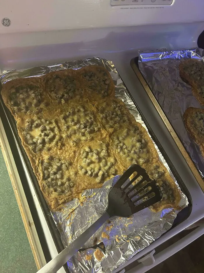 Flat, overcooked chocolate chip cookies merged together on a baking sheet, showing a baking fail.