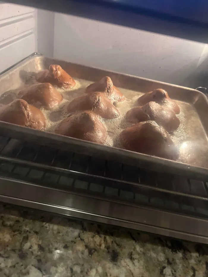 Overly bubbled pastries on baking tray in oven showcasing baking fail