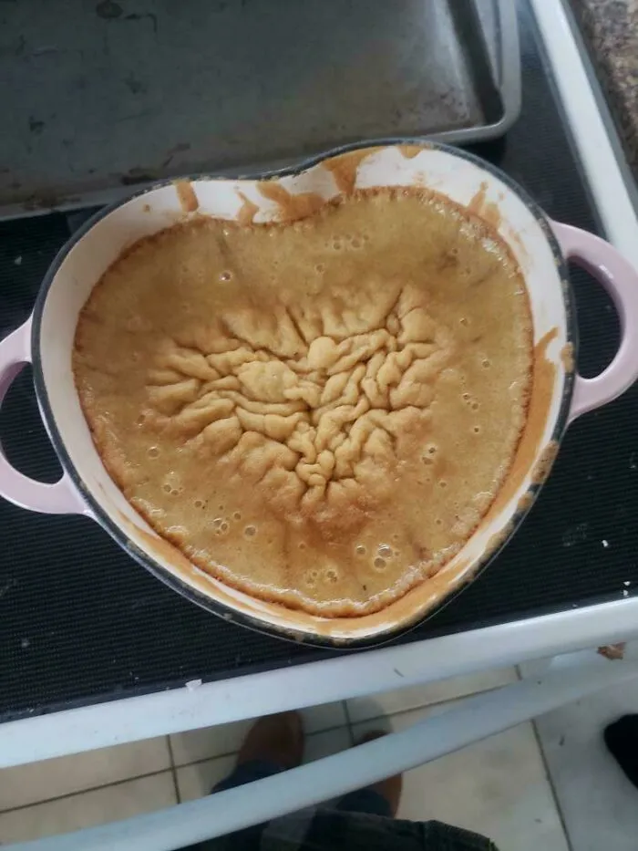 Wrinkled sunk cake inside heart shaped pan showing baking fail