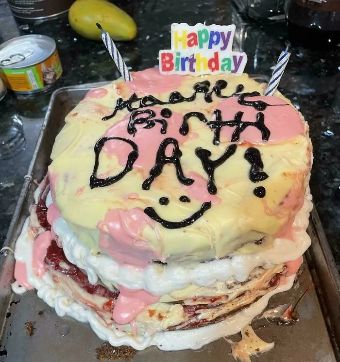 Messy layered birthday cake with melting pink icing showing a funny baking fail.