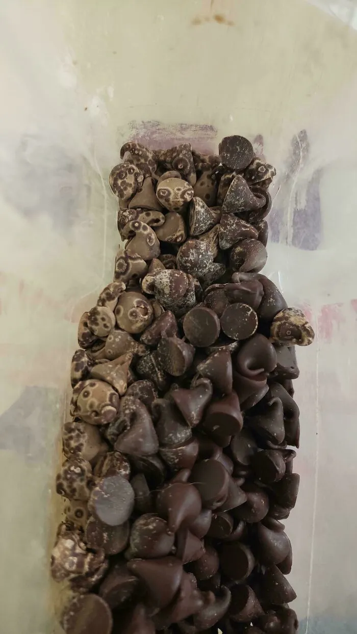 Old chocolate chips with bloom and white spots stored in a plastic bag during a bakingfail.