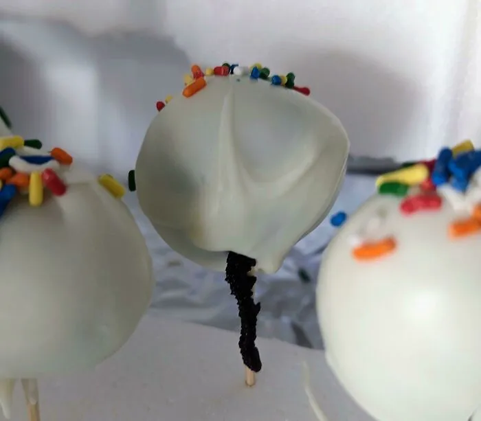 A close-up of cake pops coated in white frosting as an example of a bakingfail.