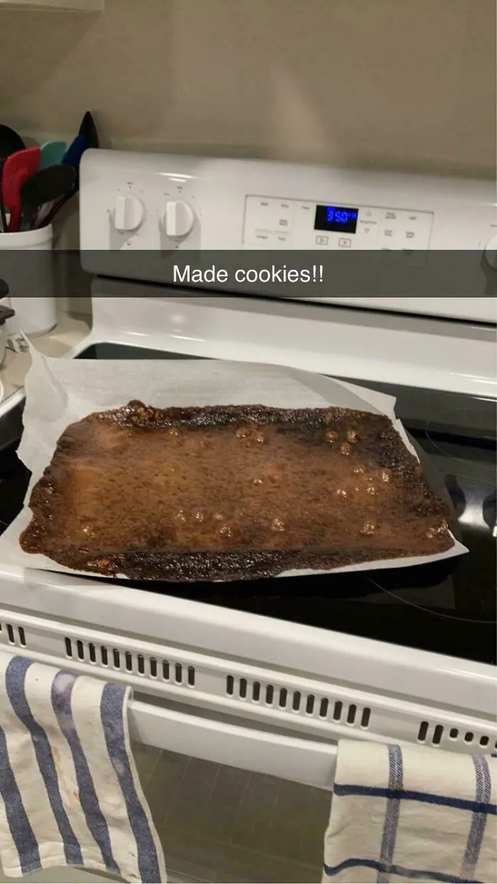 Baking fail where cookies melted together into one burnt layer on a baking sheet.