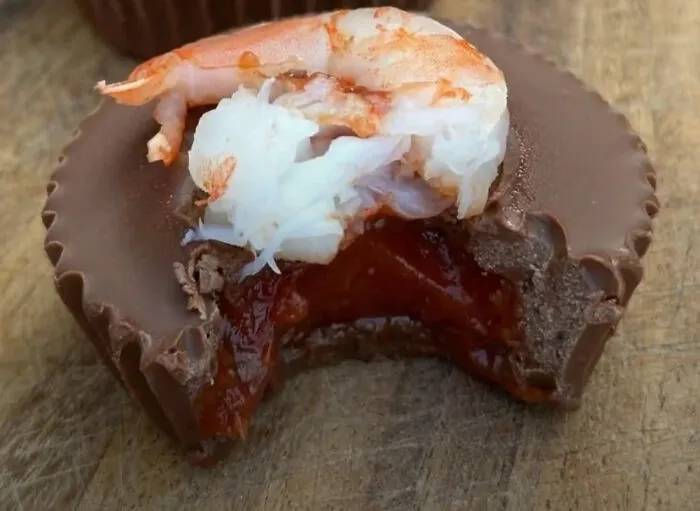 A chocolate peanut butter cup topped with a shrimp, part of cursed images.