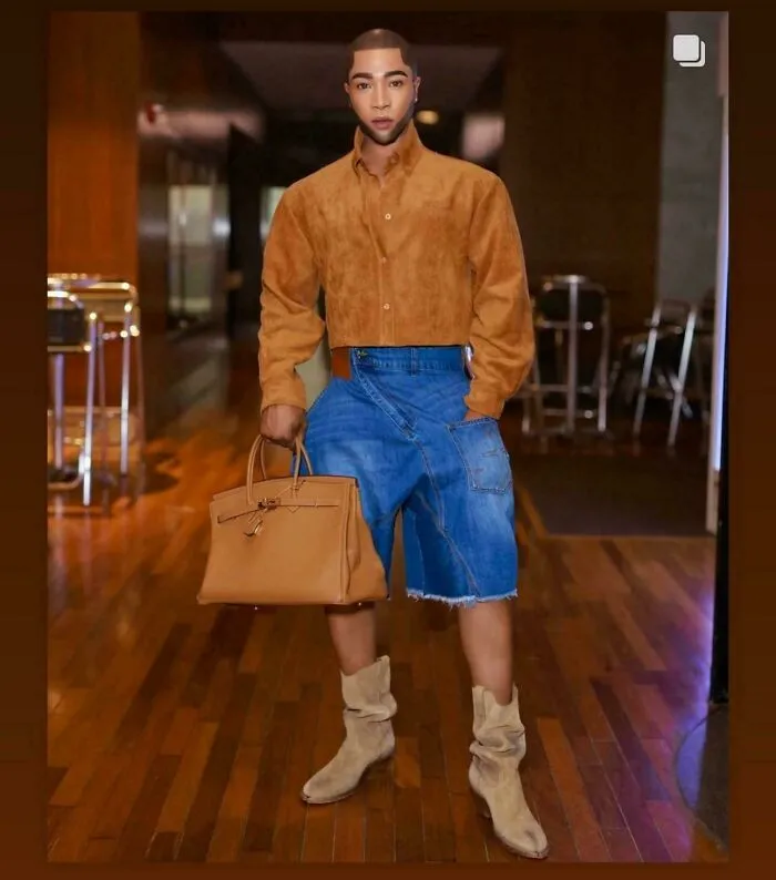 Ridiculously edited photo of a man wearing unusual combination of cropped pants and boots indoors