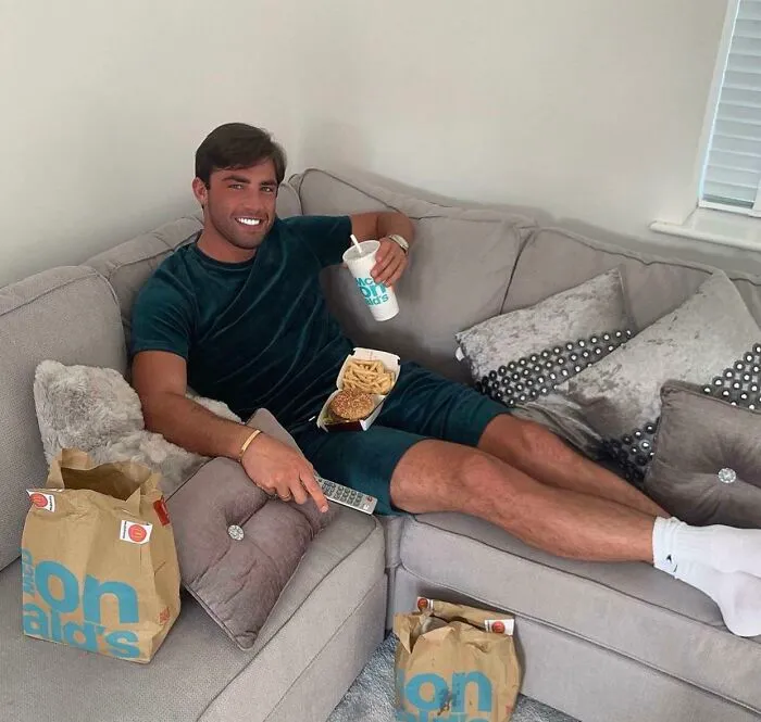 Edited photo of man relaxing with fast food on couch