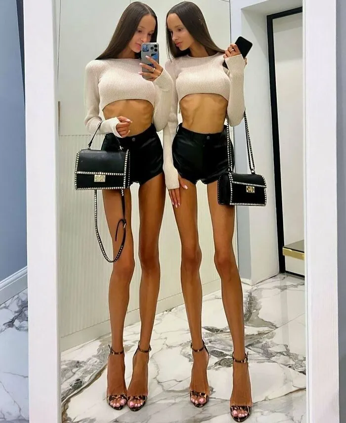 Ridiculously edited photo of twin women with extremely elongated skinny legs