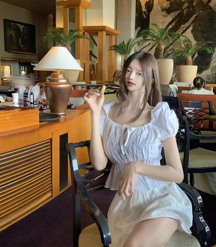 Woman sitting with elongated arm and edited body proportions