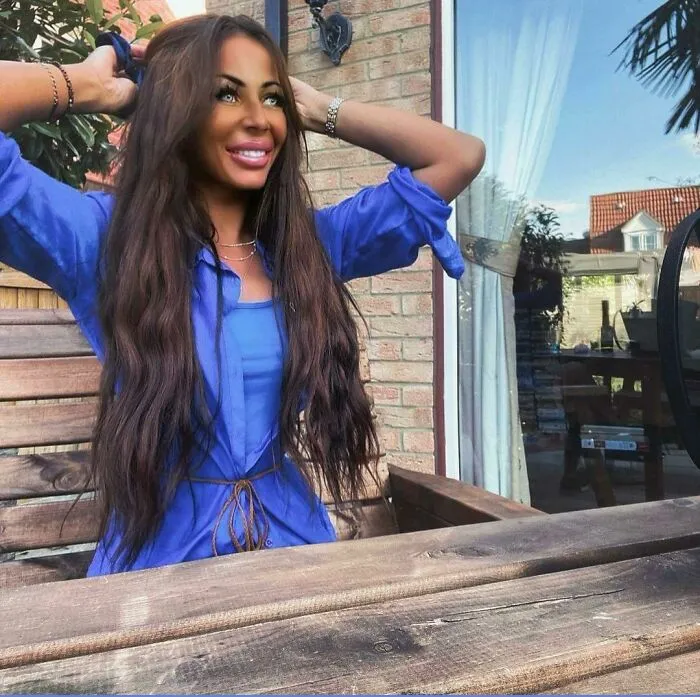 Woman with edited smiling face in blue outfit at outdoor patio