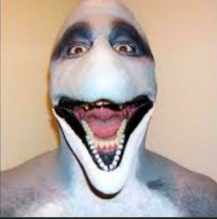 A person wearing a terrifying dolphin mask with an open mouth, included in cursed images.