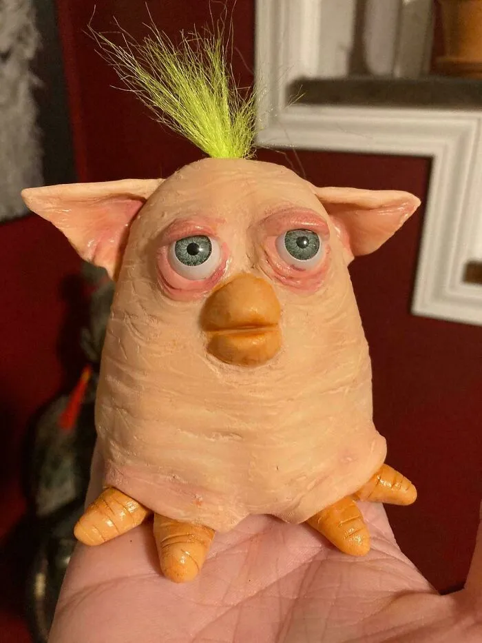 A weird skin-colored toy with human-like eyes and a beak, one of the most cursed images.