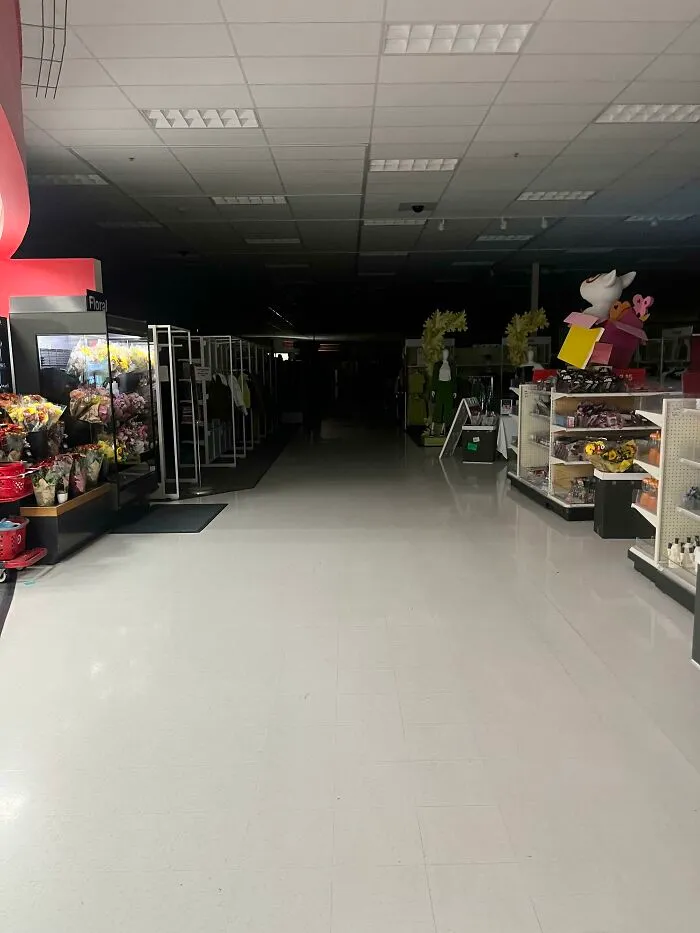 An eerie, dimly lit aisle inside an empty department store featured in creepy stories.
