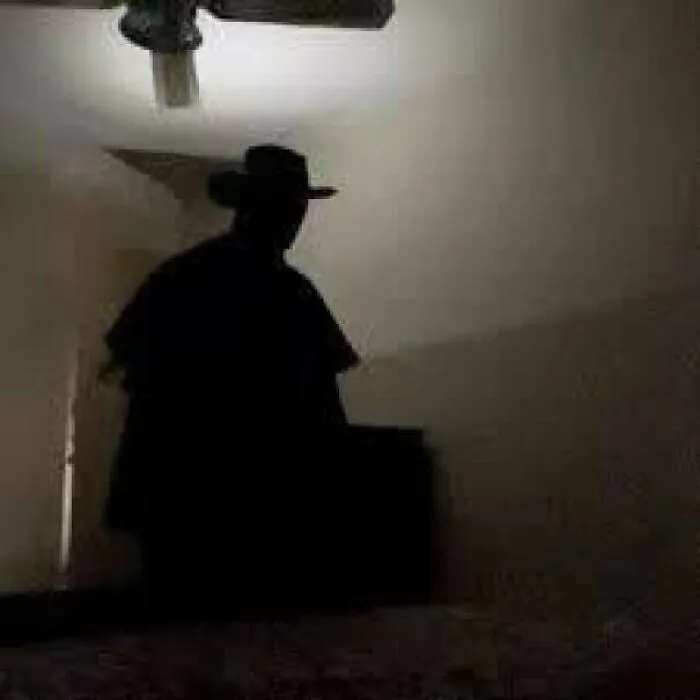 Creepy photos featuring a dark shadowed figure wearing a hat standing ominously inside a dimly lit room.