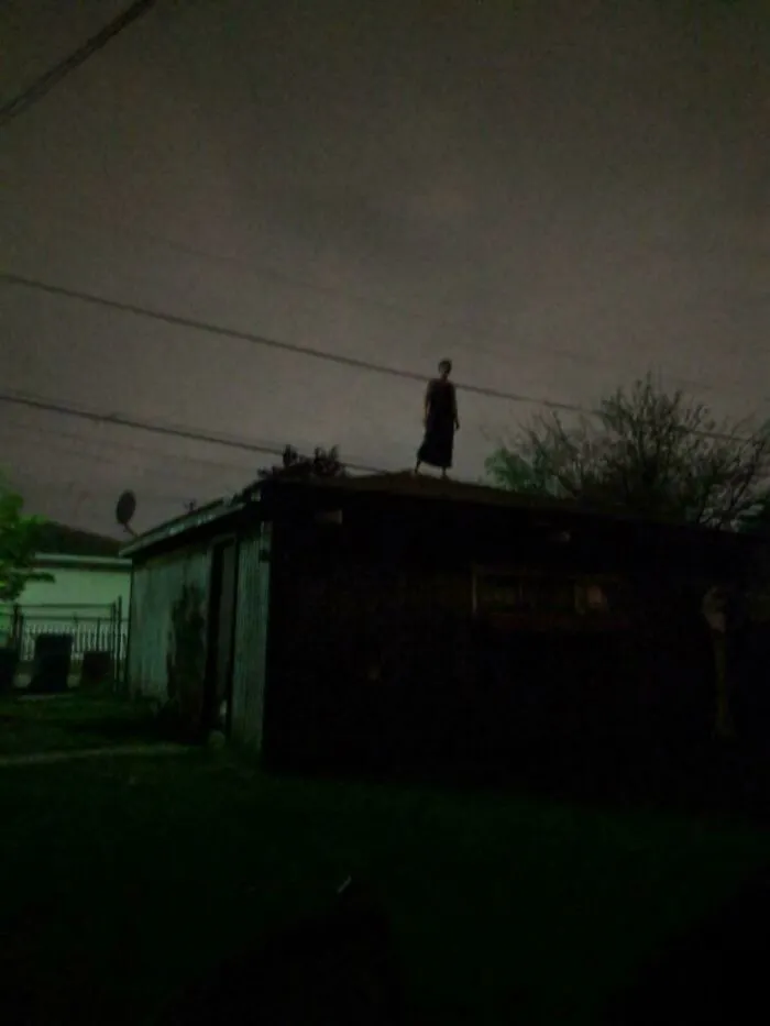 Creepy photos show a dark shadowy figure standing alone on a rooftop at night